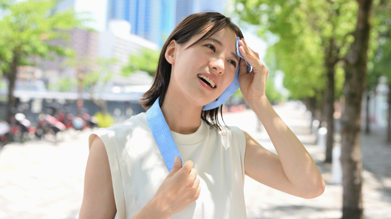 A woman wiping sweat off her forehead after a workout