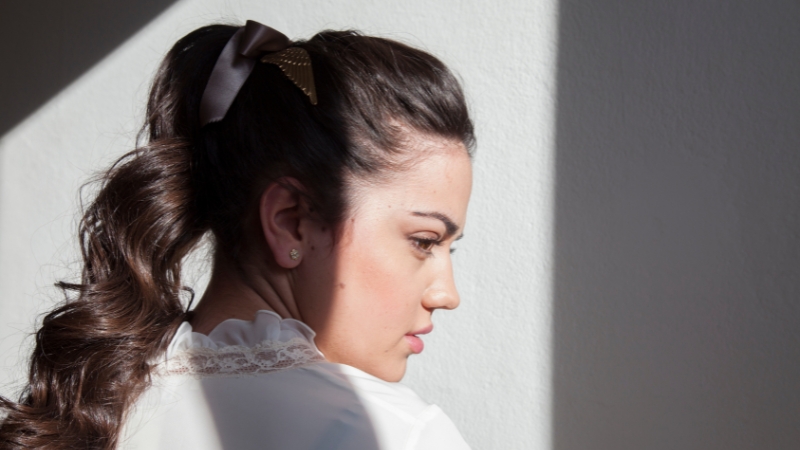 A woman with a tight ponytail, showing potential hair damage