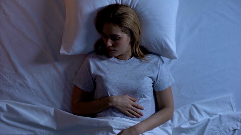 A person lying in bed, highlighting the importance of sleep for metabolism during menopause