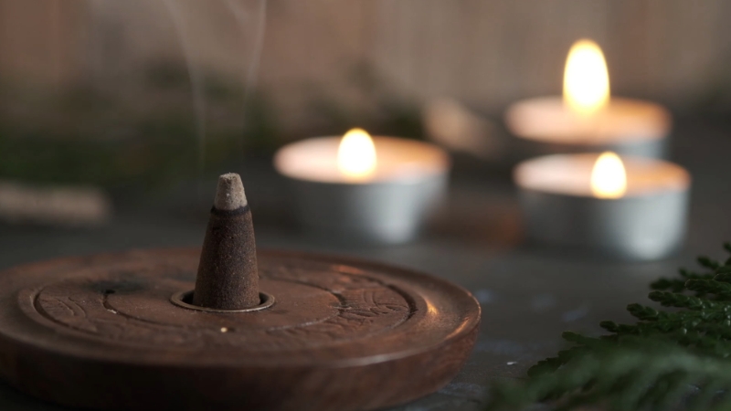 Incense cone and candles burning softly to show how aromatherapy can be used to boost mood naturally