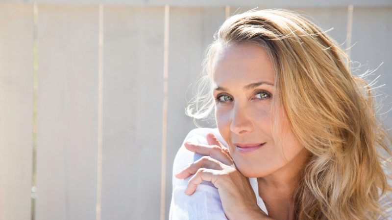 A confident woman with long blonde hair looks calm and strong, showing confidence boosters after 40