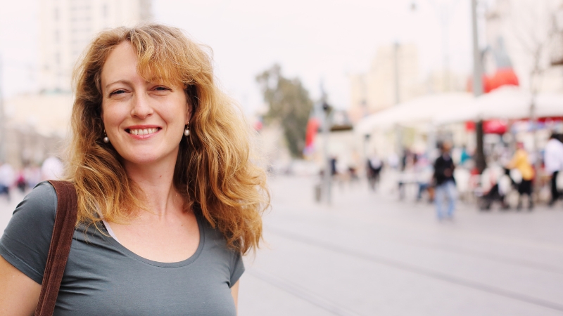 A smiling woman stands outdoors, showing personal growth after 40 with confidence and ease