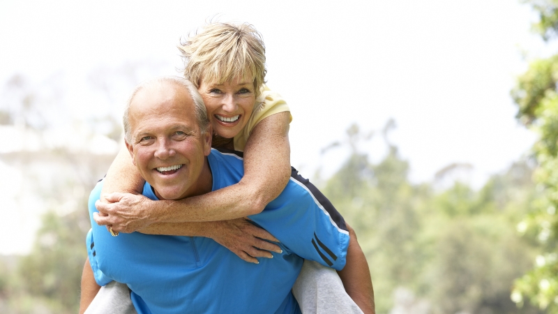 Happy older couple outdoors, smiling and enjoying time together while coping with menopause changes