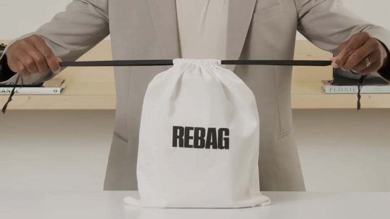 Placing a favorite bag inside a white REBAG dust cover