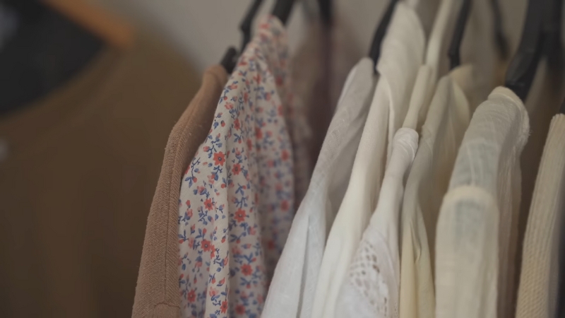 Neutral tops and blouses on hangers as part of a capsule wardrobe