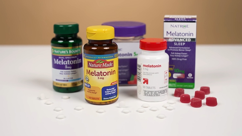 Several melatonin supplement bottles and gummies arranged on a table for sleep support